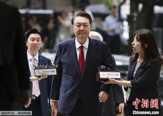 当地时间2025年7月9日，韩国首尔，韩国前总统尹锡悦（中）抵达法院，出席特别检察官要求审查其逮捕令的听证会。图/视觉中国