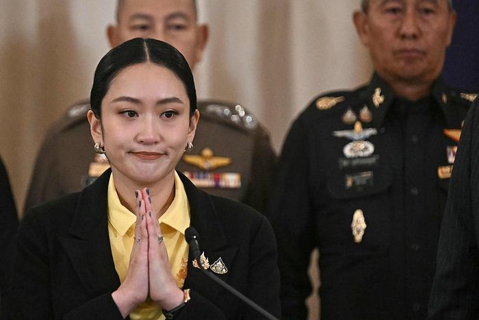 7月9日，他信（前排左三）出席泰国民族电视台活动现场，背景为洪森与他信的合照 《民族报》